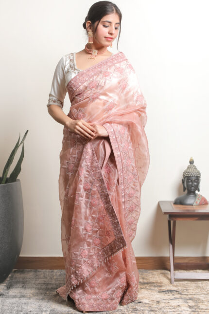 Image of a Srajann Hand Embroidered Peach Organza Lucknowi Chikankari Saree With Blouse: A delicate peach organza saree adorned with intricate Lucknowi Chikankari hand embroidery, accompanied by a matching blouse