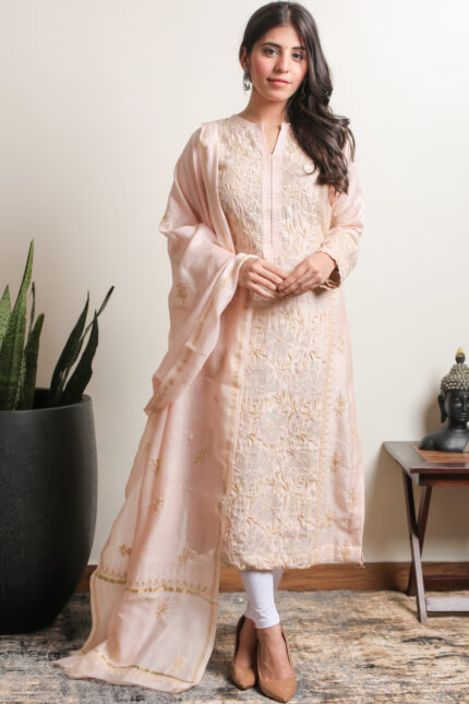 A stunning fawn mul Chanderi kurta dupatta set featuring intricate Lucknowi Chikankari embroidery by Srajann.