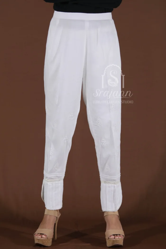 White Cotton Lucknowi Chikankari Straight Pants with Hand Embroidery The pants feature intricate hand-embroidered floral motifs, adding an elegant touch to the classic design.